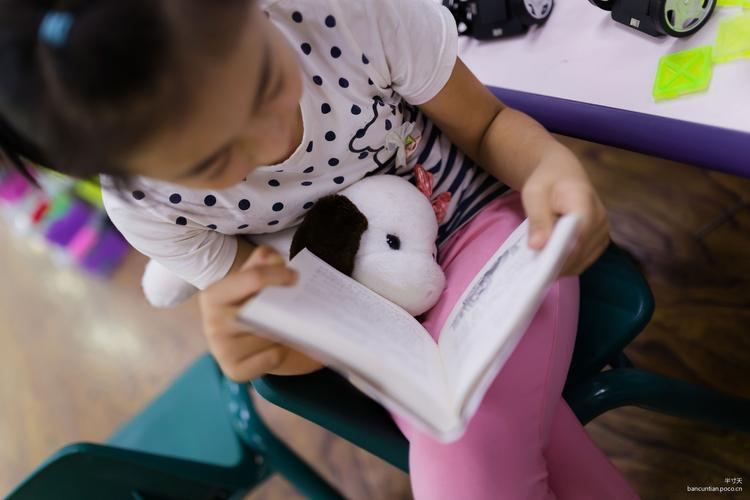 小学低年级孩子对着毛绒玩偶讲课文的日常居家场景