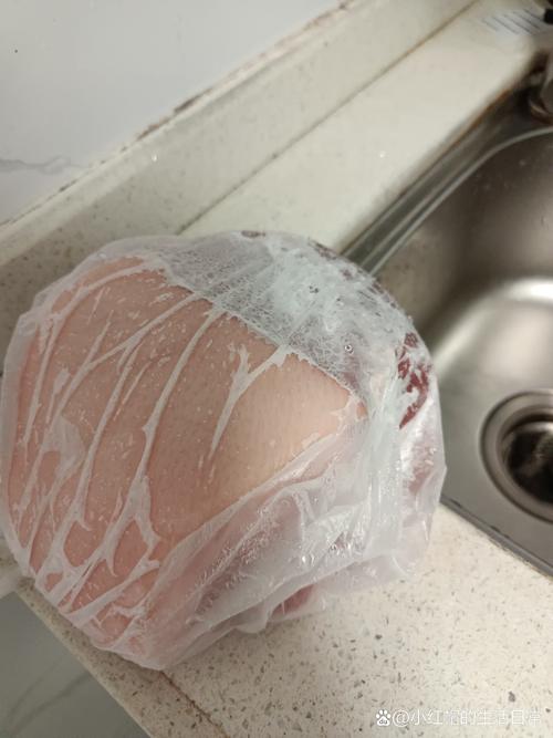 密封袋封装的冻肉放在流动冷水下解冻的厨房场景