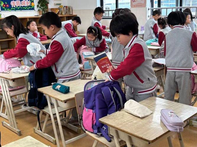 小学教室旧物市集项目学生围坐整理闲置物品的实拍图