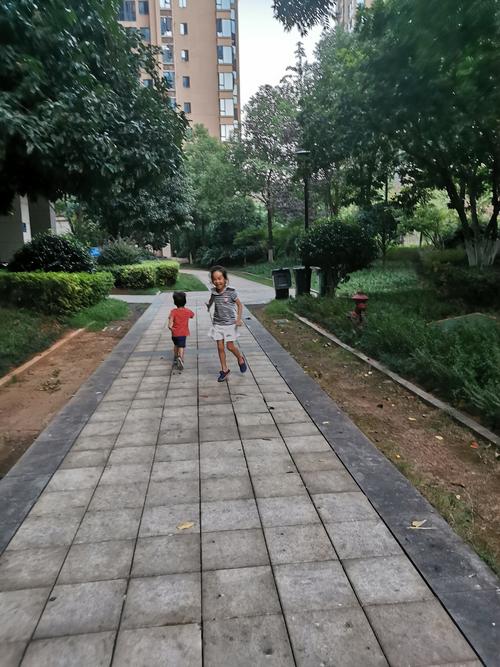 小区楼下亲子散步追逐休闲运动场景