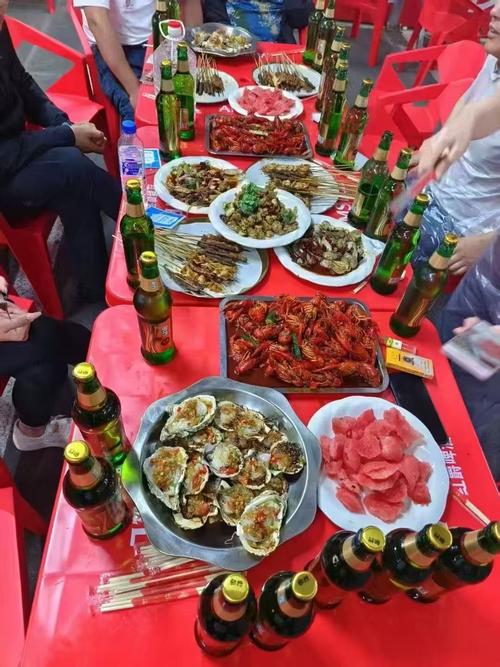 聚餐时桌上摆放着冰啤酒和麻辣水煮鱼的实拍图