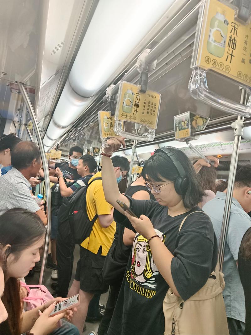 成都地铁车厢内拥挤的乘客,有人站着吃蛋烘糕