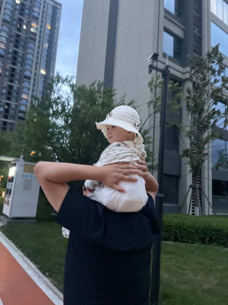 父亲将婴儿举高高互动的温馨场景