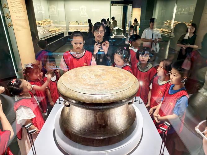 研学旅行孩子在博物馆里用放大镜观察青铜器纹饰