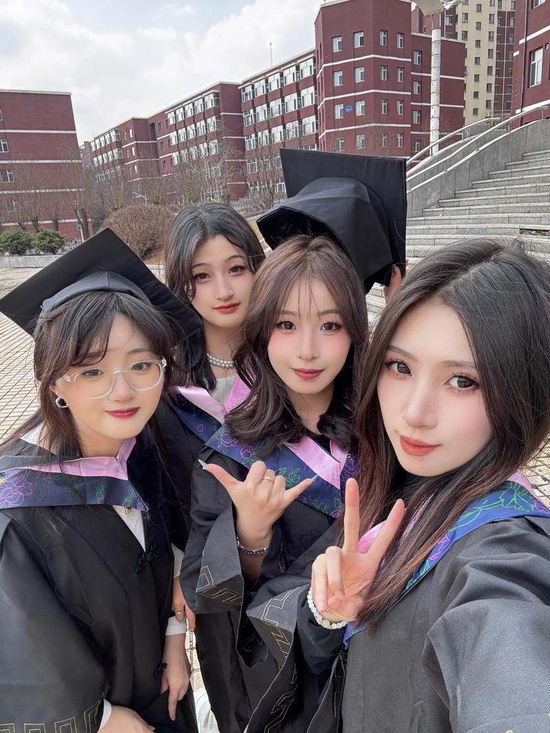 毕业季穿学士服的大学生站在校园门口