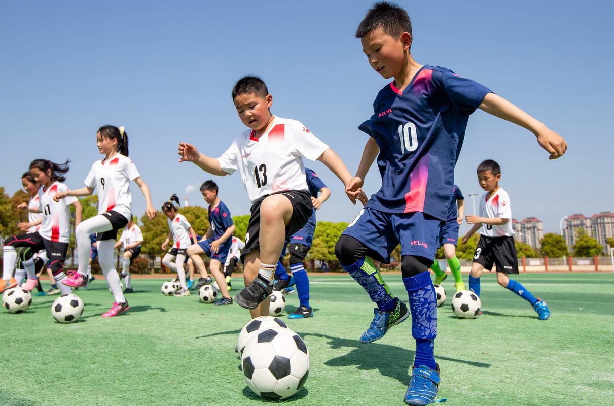 小学足球课孩子们做带球游戏