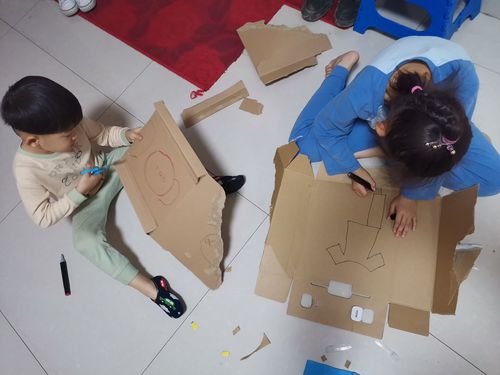 孩子和妈妈一起用鞋盒制作书架开心的场景图