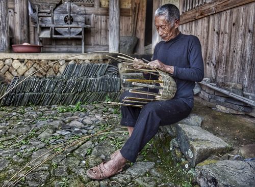 南溪古寨金氏宗祠门口编竹篮的老人