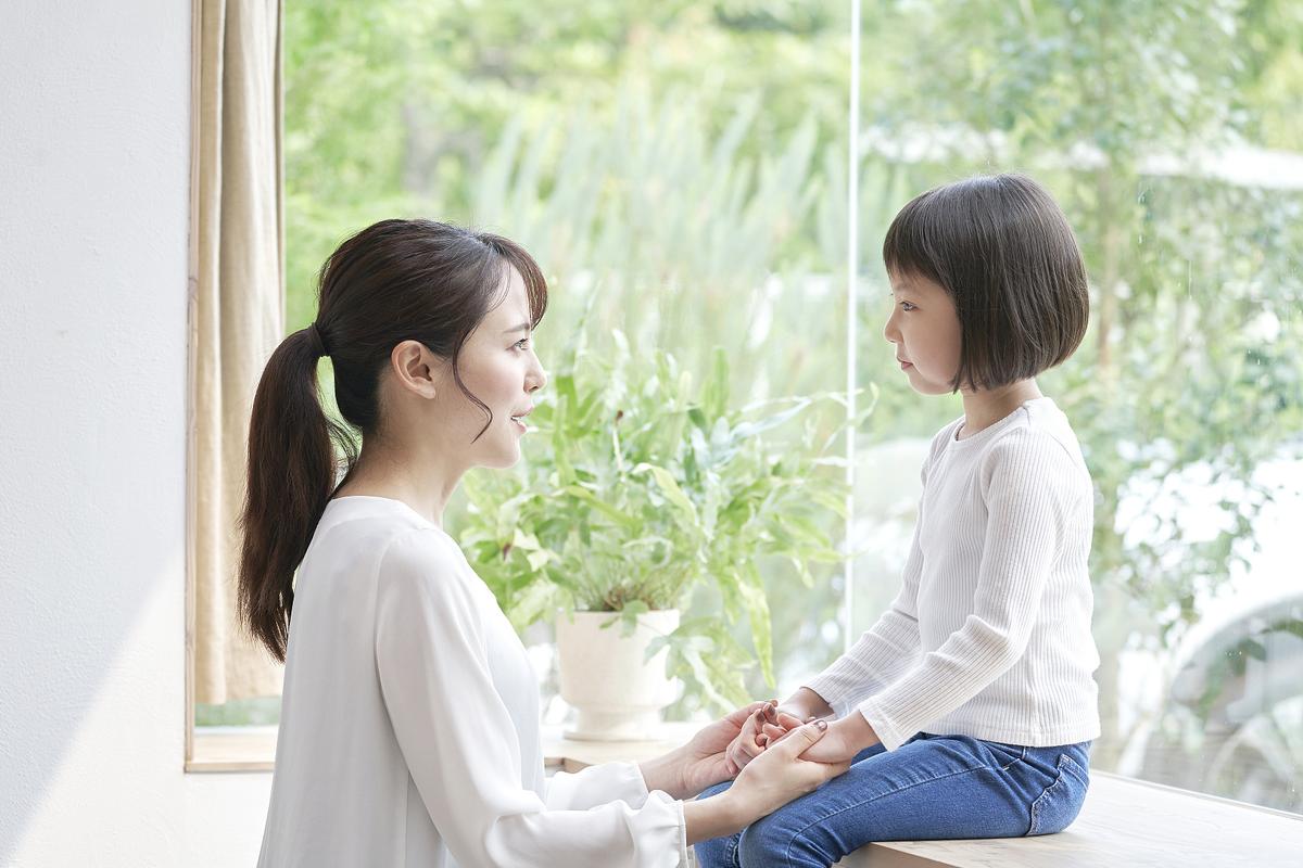 妈妈与孩子依偎在沙发亲子共读的温馨画面