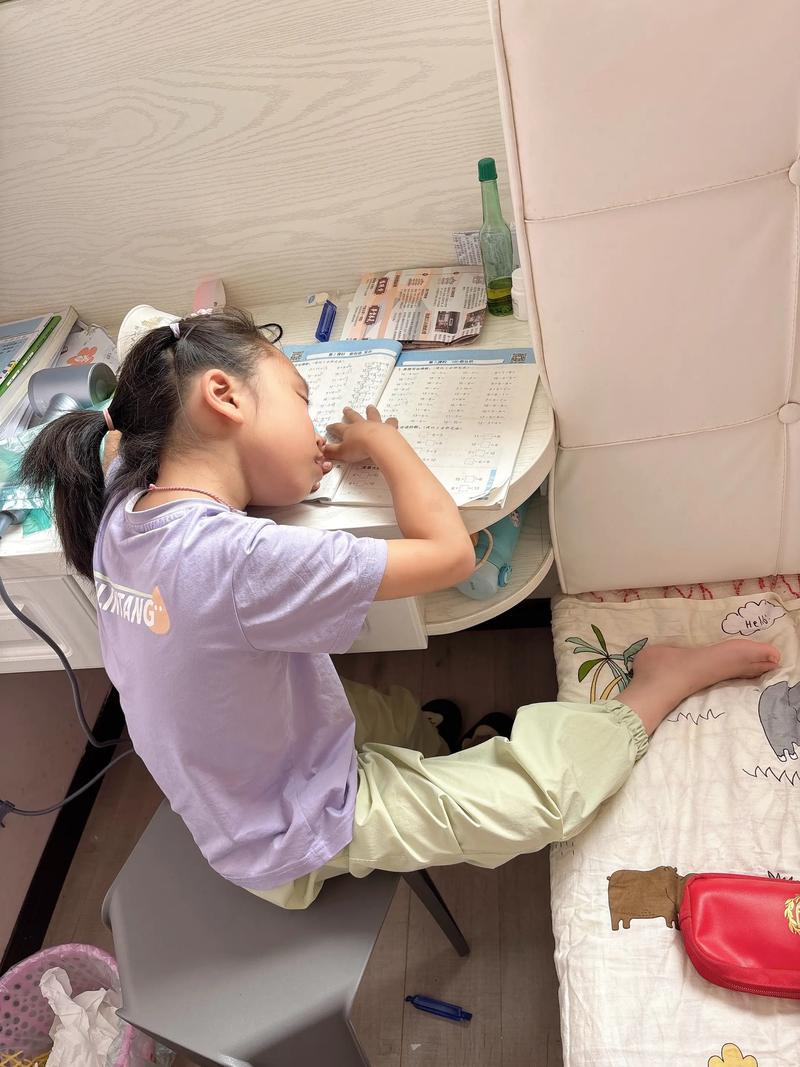 寄宿家庭孩子趴在旧书桌上写作业