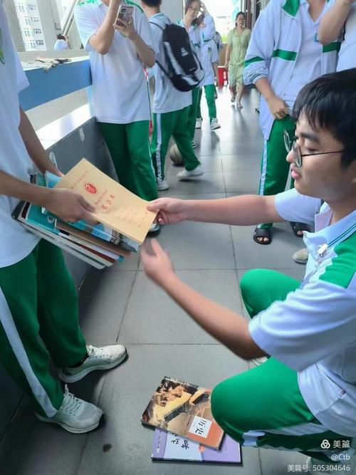 中学教室学生课间帮邻座捡掉在地上的笔的抓拍图