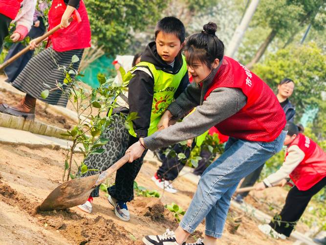 家长陪孩子在厂区种植小树苗的亲子活动图