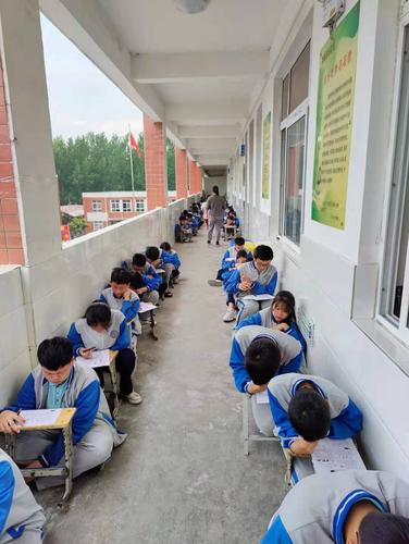 初中教学楼走廊 学生靠在墙边低头看书