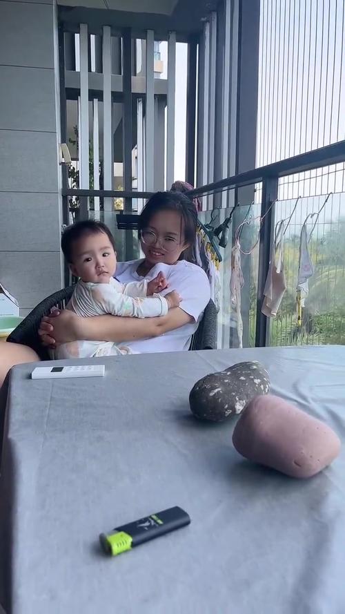 妈妈抱着宝宝在阳台看云享受片刻宁静