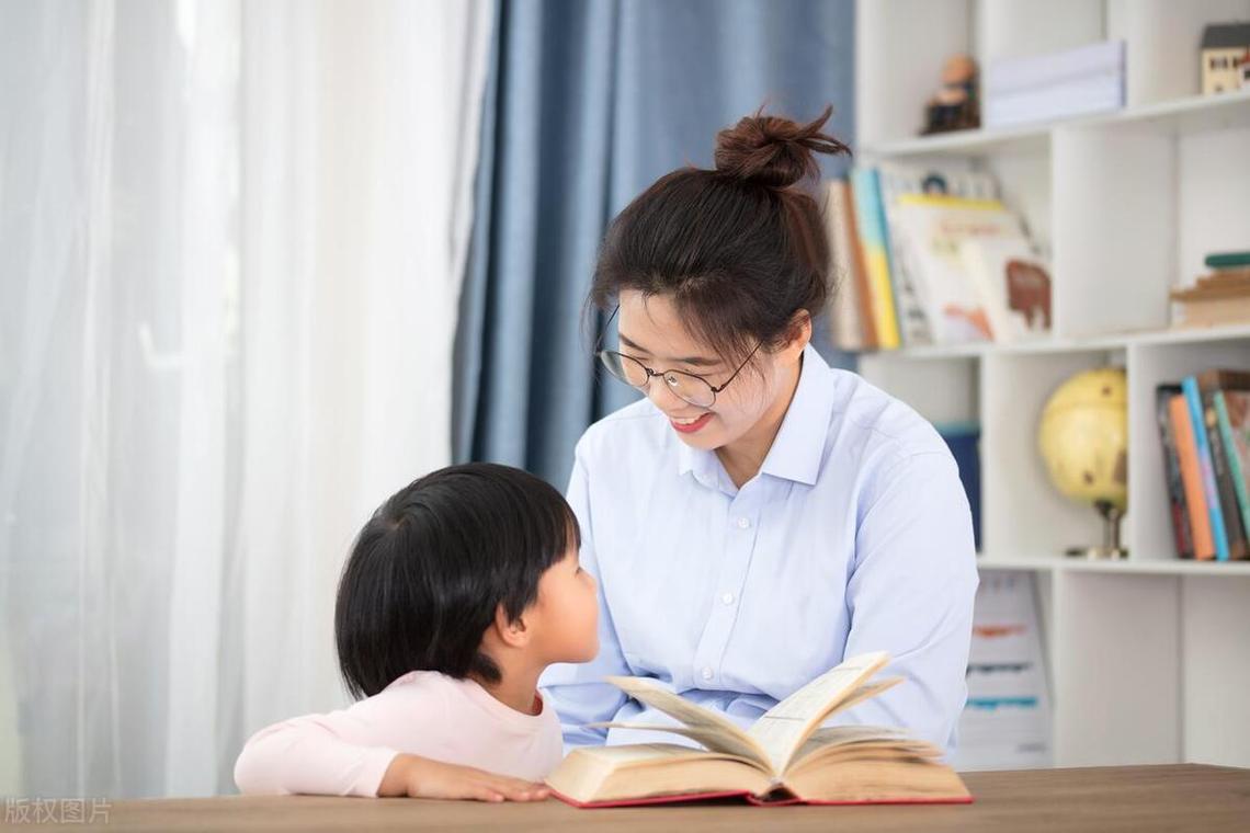 母亲指着书本向孩子提问