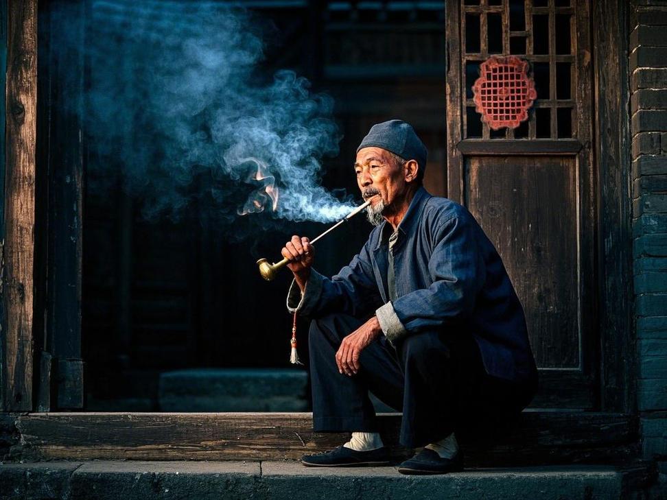 西安明城墙根坐马扎抽旱烟的老人
