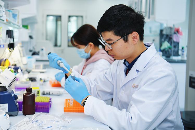 高校实验室走廊饮水机旁穿白大褂的青年科研人员