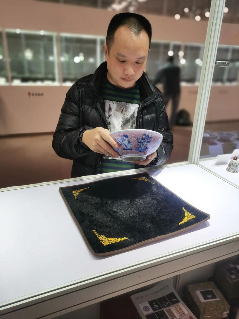 穿西装的鉴定师对着农户家传青花碗做鉴定场景
