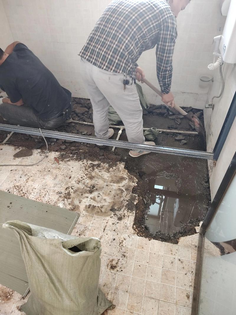 装修工人正在修补卫生间漏水的施工场景