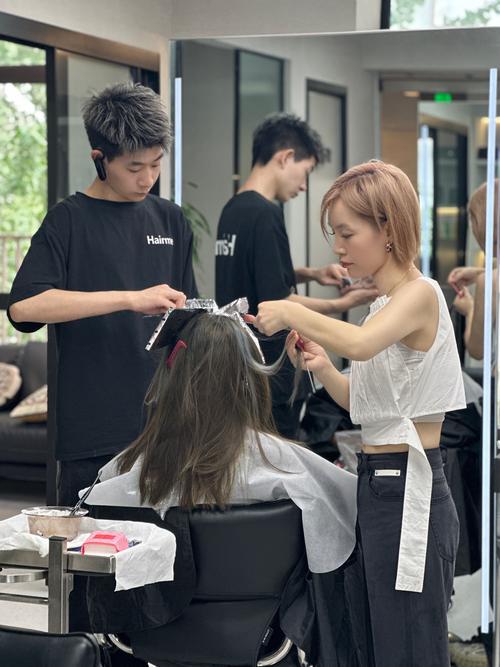 理发店镜子前顾客拿照片与发型师沟通