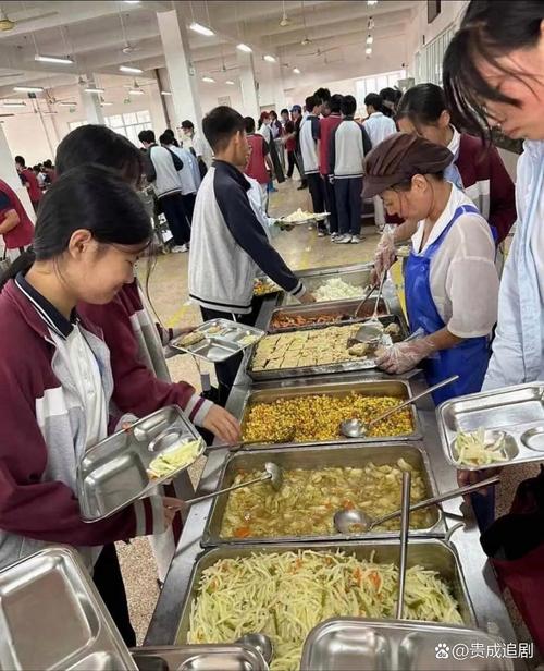 中学食堂里独自坐位置低头扒饭的初中生