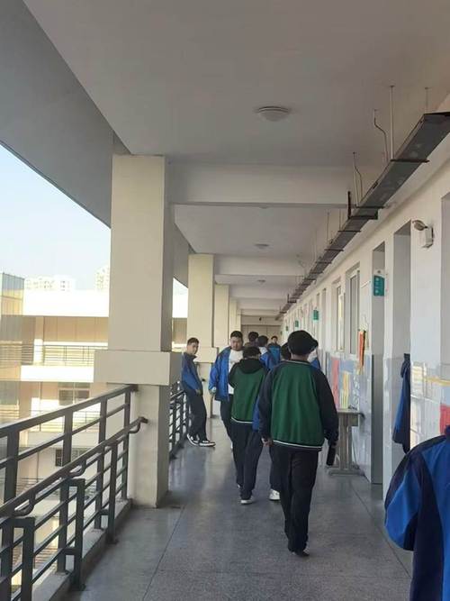 高中课间学生围在走廊栏杆边闲聊的松弛日常