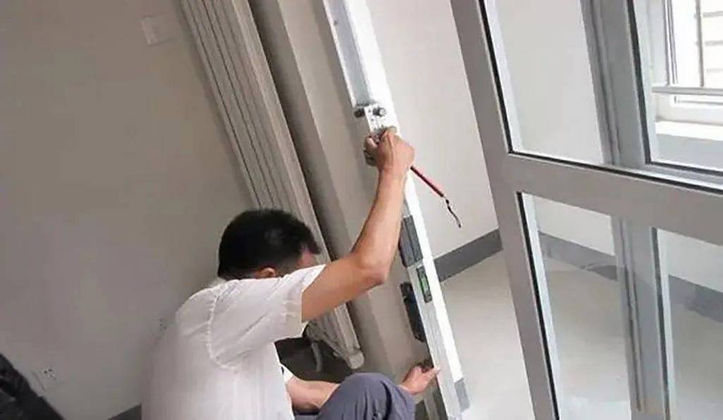 门窗安装师傅用水平仪校准窗框垂直度