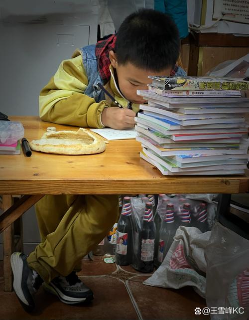 小学生趴在书桌前对着摞得很高的习题册发呆