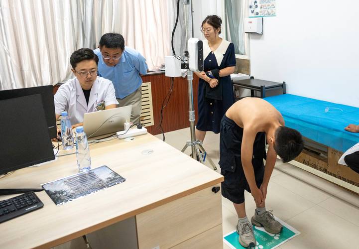家长在家给青少年做脊柱侧弯弯腰筛查实拍图