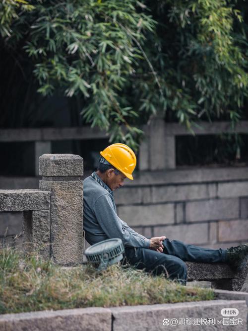 中年工人蹲在厂区路边看手机的落寞背影