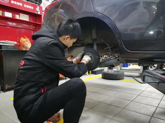 汽修师傅手捏刹车软管检查鼓包作业图