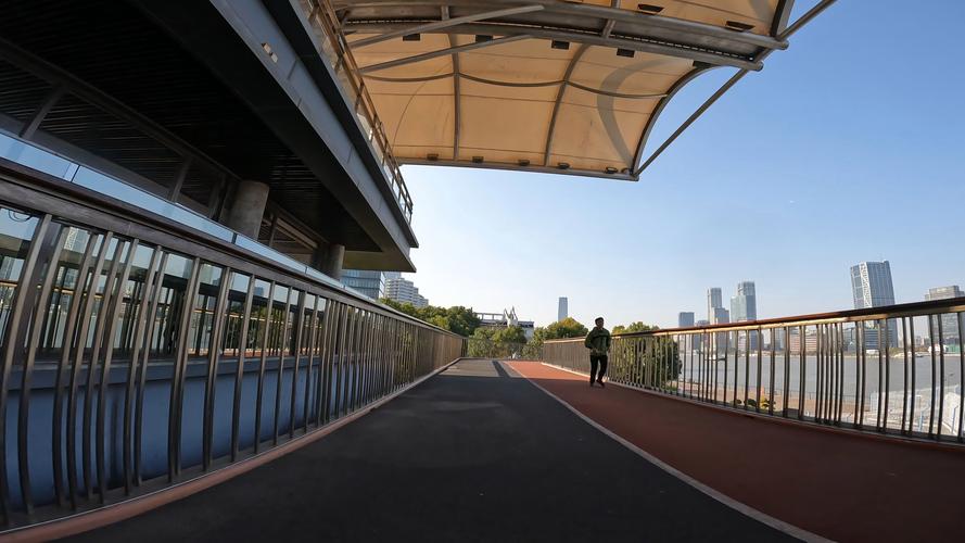 城市滨江绿道休闲骑行的普通路人侧影
