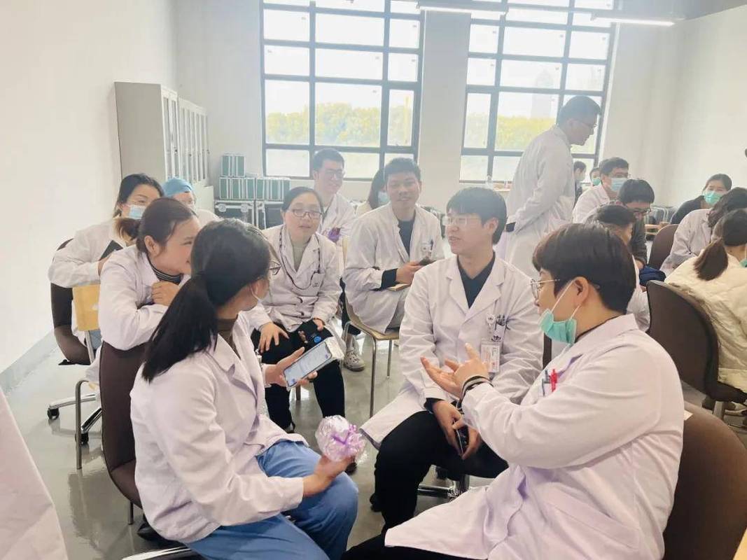 医生拿着执业医师资格证书与同事讨论病例
