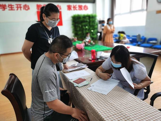 小学门口家长接孩子看培训机构宣传单场景