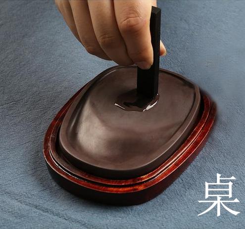 砚台上研磨老墨条细节特写