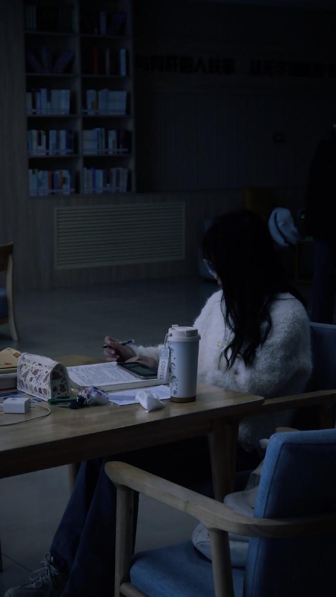 学生深夜在昏黄灯光下疲乏地趴在书桌上