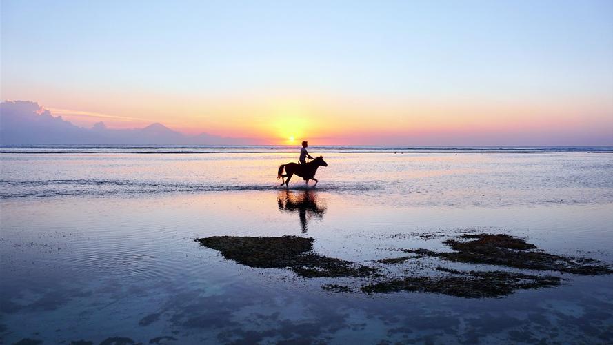 青海湖黑马河日出橘红湖面骑行者剪影