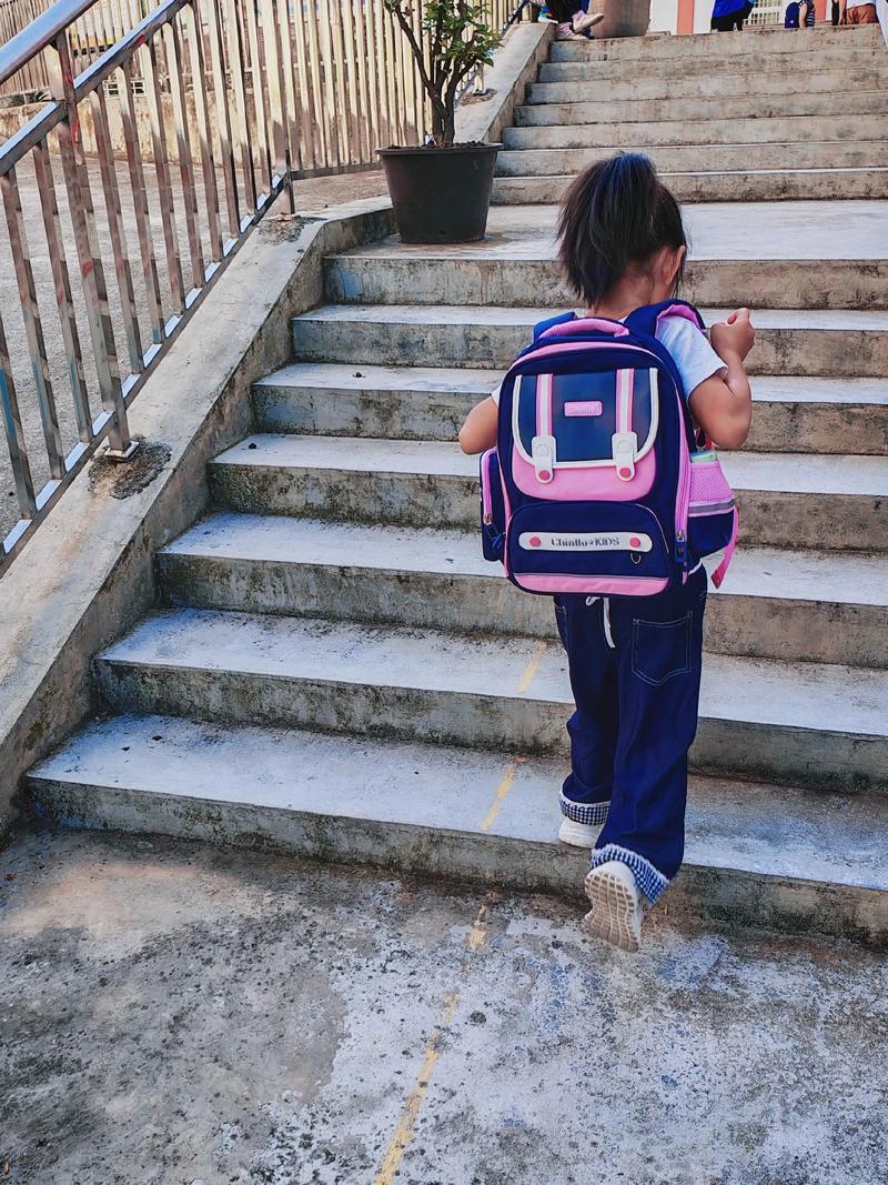 清晨孩子在家附近的普通小学开心上学的背影
