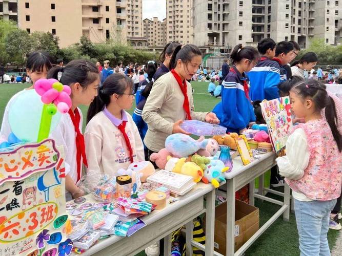 小学生在教室旧物市集给同学介绍闲置商品的实拍图