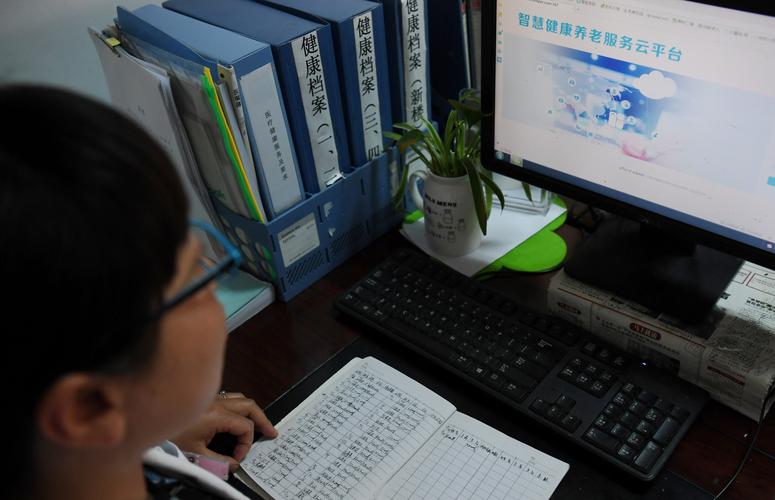 居民在家对着电脑填写保险健康告知表单的日常场景