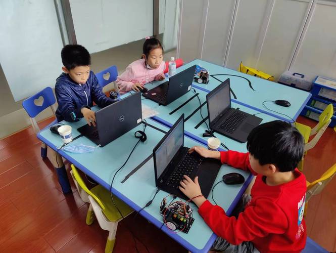 少儿编程竞赛考场学生对着题目写标准答案的实景