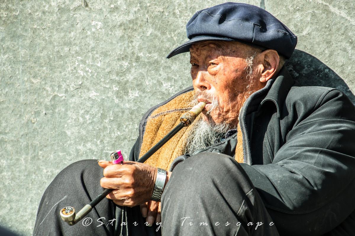 西安安定门城墙根抽旱烟的老人