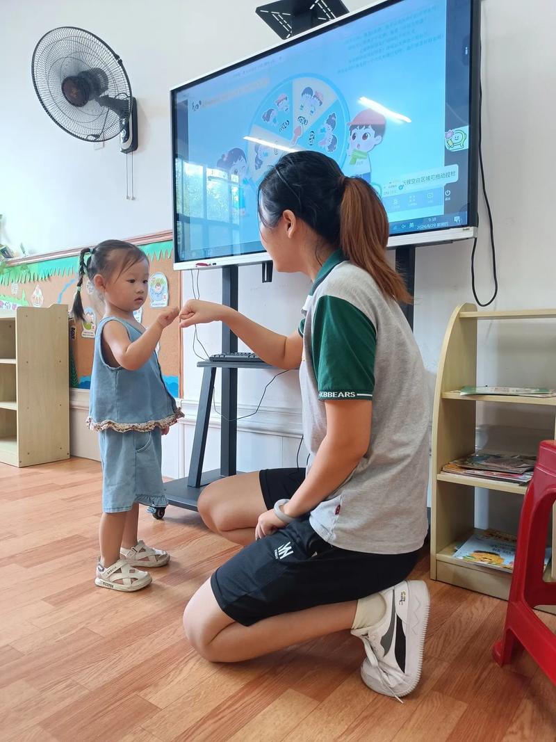 小班化教学课堂中老师蹲在学生旁辅导特写
