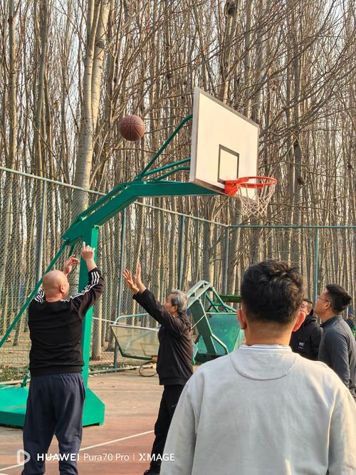 退休钢铁厂工人爷爷带孙子在厂区篮球场玩耍照片