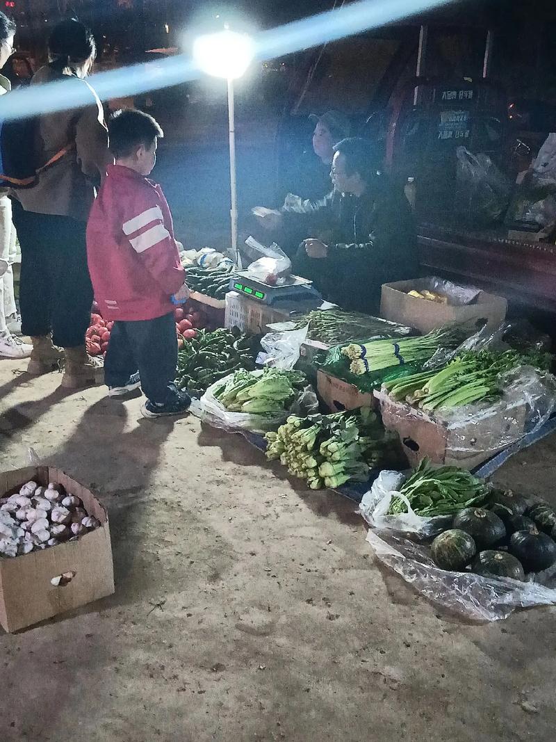 个体户孩子在菜摊旁写作业的夜晚场景