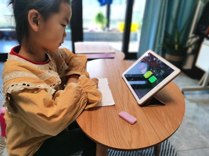 家用餐桌上小孩用手机学拼音实拍