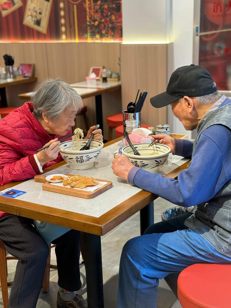 一对中年夫妻在小面馆后厨一起准备食材，灯光温暖
