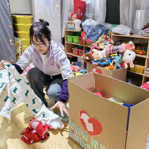 三岁宝宝整理闲置玩具放入志愿服务捐赠箱