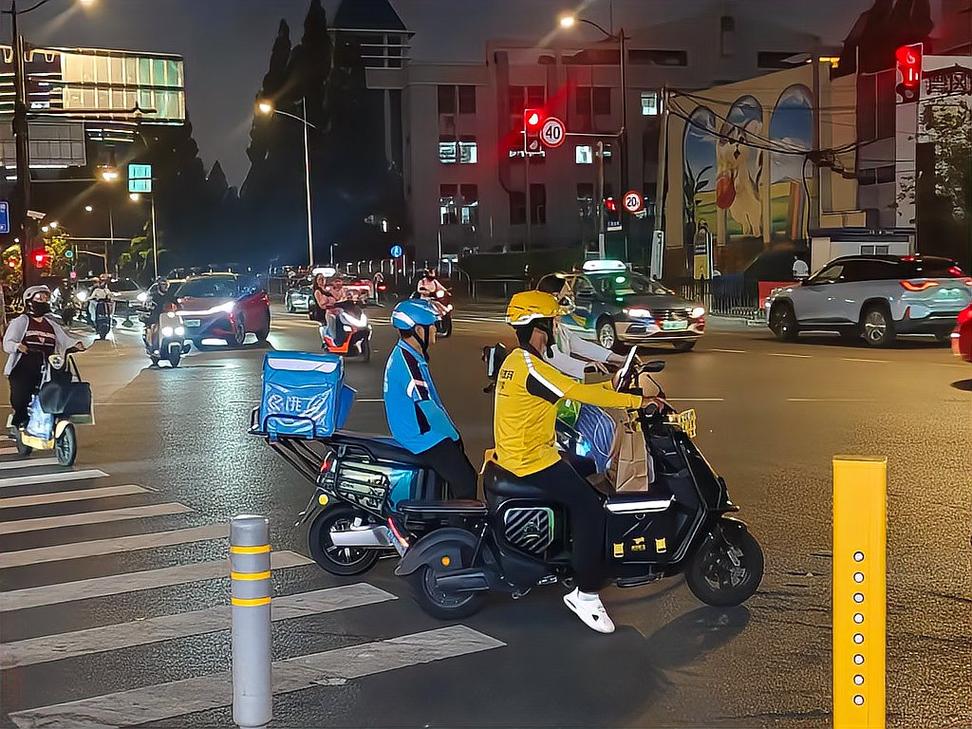 外卖骑手在晚高峰机动车道等红绿灯场景