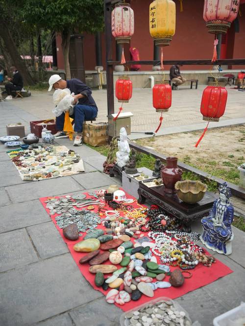 德州苏禄王墓旁古玩地摊清晨摊主铺帆布摆货的场景